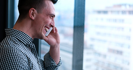 Image showing Business Man Talking On Cell Phone, Looking Out Office Window