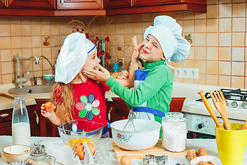 Image showing happy family funny kids are preparing the dough, bake cookies in the kitchen