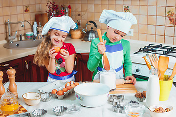 Image showing happy family funny kids are preparing the dough, bake cookies in the kitchen
