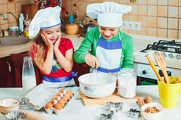 Image showing happy family funny kids are preparing the dough, bake cookies in the kitchen