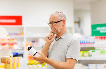 Image showing senior male customer with drug at pharmacy