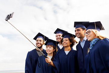 Image showing group of happy students or graduates taking selfie