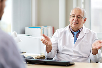 Image showing senior doctor talking to male patient at hospital