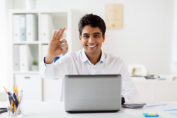 Image showing businessman with laptop showing ok sign at office