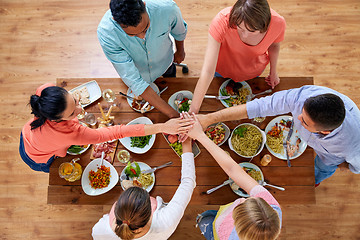 Image showing people holding hands together over table with food