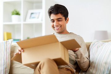 Image showing happy man opening parcel box at home