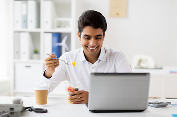 Image showing businessman with laptop eating fruits at office