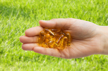 Image showing hand holding cod liver oil capsules