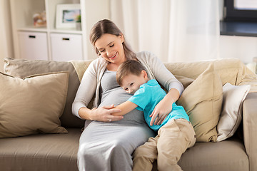 Image showing happy pregnant mother and son hugging at home