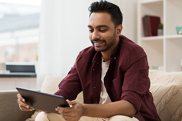 Image showing smiling man with tablet pc at home