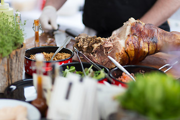 Image showing Cheff serving traditional meat dish on street stall on street food festival, Ljubljana, Slovenia.