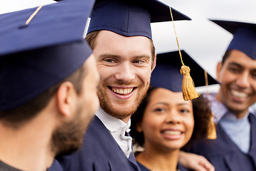 Image showing happy students or bachelors in mortar boards