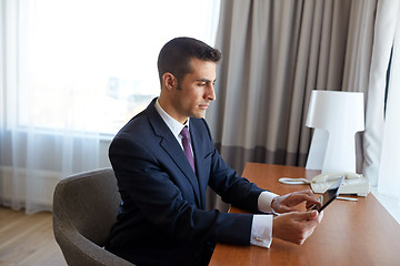 Image showing businessman with tablet pc working at hotel room