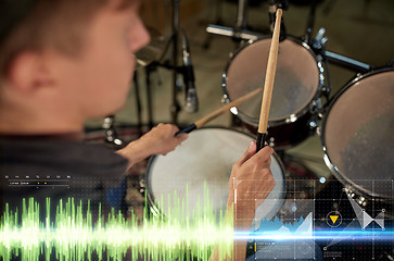 Image showing male musician playing drum kit at concert