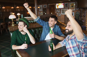 Image showing happy male friends drinking beer at bar or pub