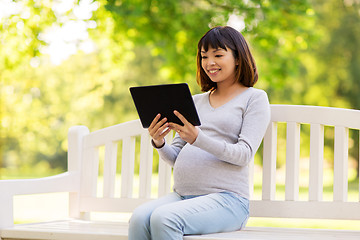 Image showing happy pregnant asian woman with tablet pc at park