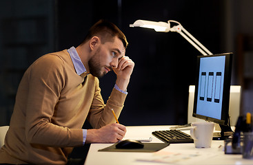 Image showing man with notepad working at night office