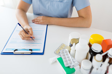 Image showing doctor with medicines and clipboard at hospital