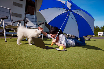 Image showing Woman on the grass with a dog looking at a laptop