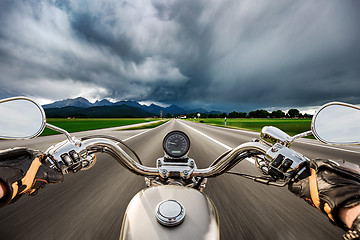 Image showing Biker on a motorcycle hurtling down the road in a lightning stor