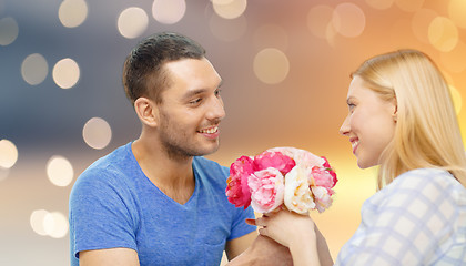 Image showing happy couple with flowers over lights background