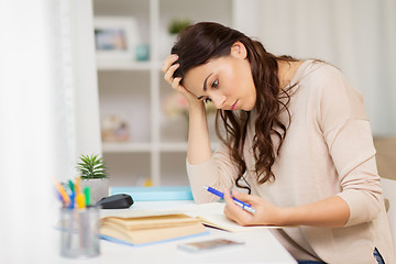 Image showing tired female student with book learning at home