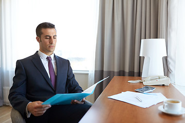 Image showing businessman with papers working at hotel room