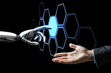 Image showing human hand and robot touching network hologram