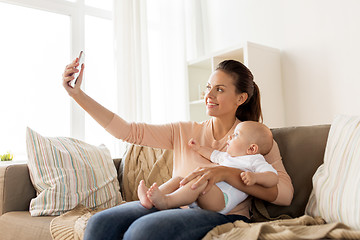 Image showing happy mother with baby boy taking selfie at home