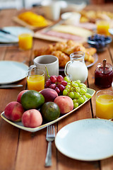 Image showing fruits, juice and other food on table at breakfast