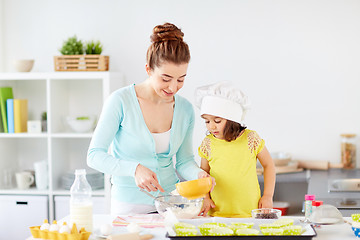 Image showing happy mother and daughter making dough at home