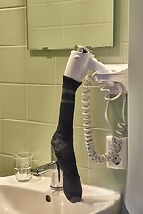 Image showing Drying sock in a hairdryer