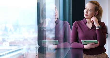 Image showing Pretty Businesswoman Using Tablet In Office Building by window