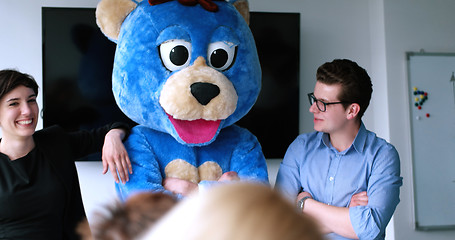 Image showing boss dresed as bear having fun with business people in trendy of