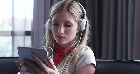 Image showing Lovely Blond Woman Listening To Music while resting on couch