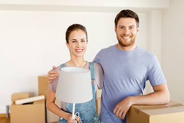 Image showing couple with boxes and lamp moving to new home