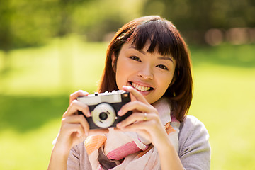 Image showing happy young asian woman with film camera outdoors
