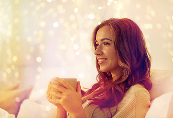 Image showing happy woman with cup of coffee in bed at home