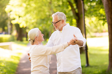 Image showing happy senior couple dancing at summer park