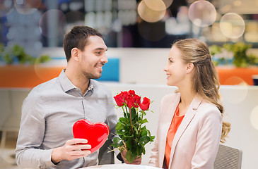 Image showing happy couple with present and flowers in mall