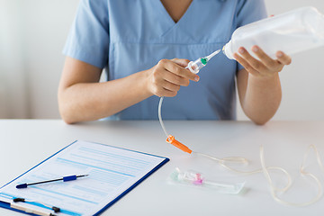 Image showing close up of nurse preparing drop counter