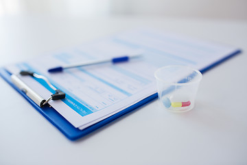 Image showing clipboard with report and drugs in medical cup