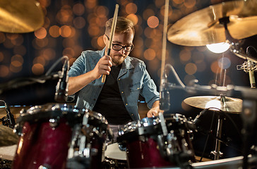 Image showing musician playing drum kit at concert over lights