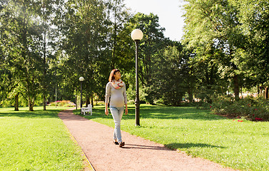 Image showing happy pregnant asian woman walking at park