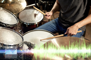 Image showing male musician playing drum kit at concert