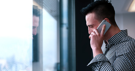 Image showing Business Man Talking On Cell Phone, Looking Out Office Window