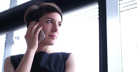 Image showing Business Girl Standing In A Modern Building Near The Window With