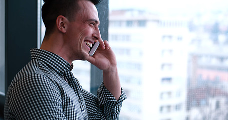 Image showing Business Man Talking On Cell Phone, Looking Out Office Window