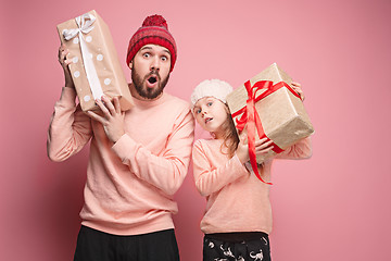 Image showing Portrait of a surprised little girl with her father holding a Christmas present