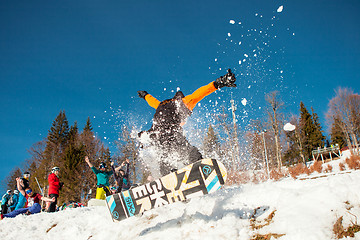 Image showing Bukovel, Ukraine - December 22, 2016: Man boarder jumping on his snowboard against the backdrop of mountains, hills and forests in the distance. Bukovel, Carpathian mountains